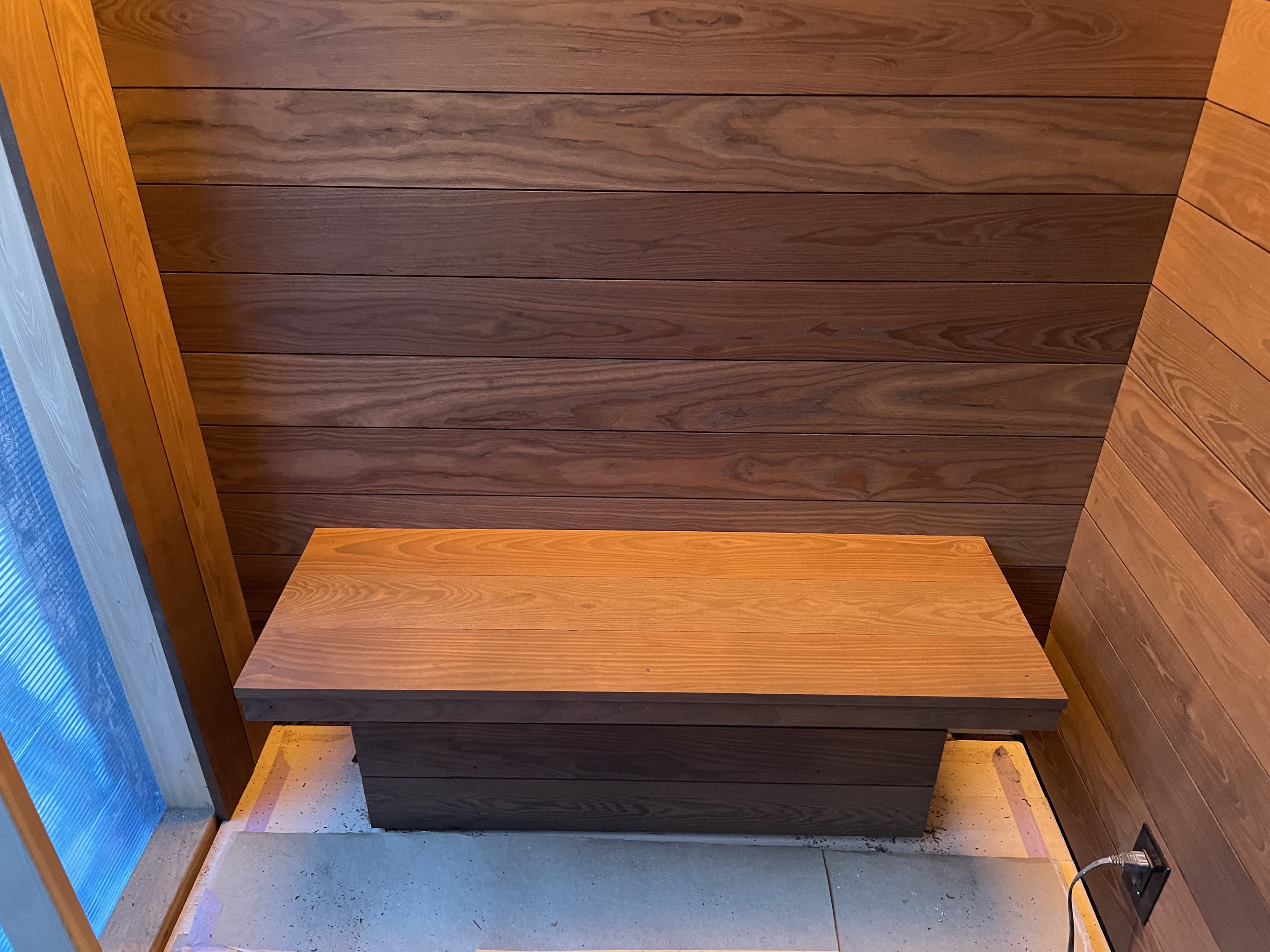 Finished sauna bench with wood paneling
